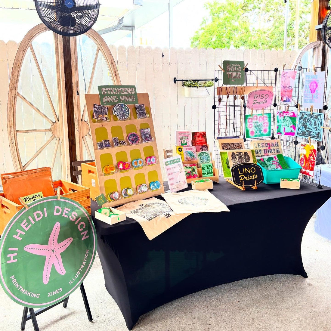 Image is of Hi Heidi Designs Art Market Setup inclduding risograph prints, linocut prints, and handmade pins and stickers